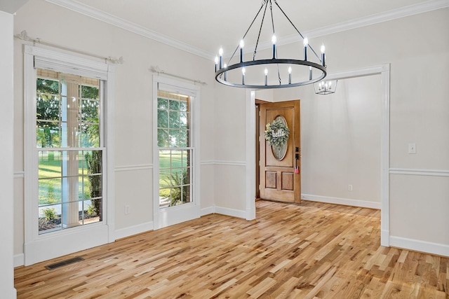 entryway with visible vents, baseboards, crown molding, light wood-style floors, and a notable chandelier