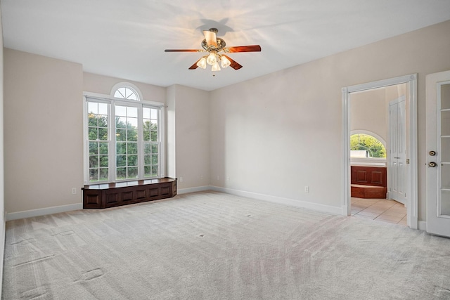 unfurnished room featuring light carpet, plenty of natural light, and baseboards