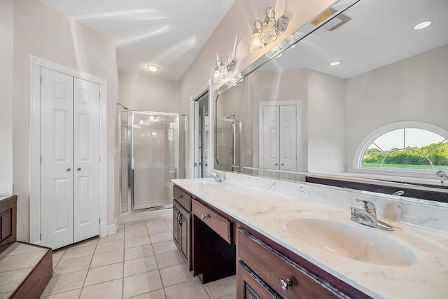 bathroom featuring a stall shower, a closet, a sink, and tile patterned floors