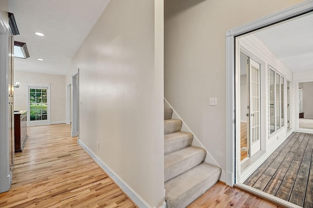 hall with baseboards, light wood-style flooring, stairway, french doors, and recessed lighting