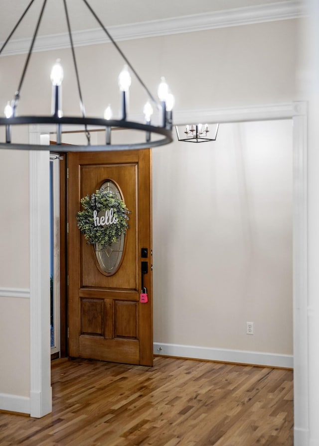 entryway with crown molding, baseboards, and wood finished floors