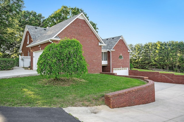 view of home's exterior featuring brick siding, a yard, concrete driveway, an attached garage, and fence