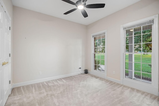 empty room with ceiling fan, visible vents, baseboards, and light colored carpet