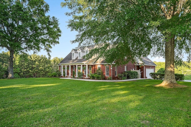 cape cod house featuring an attached garage, covered porch, brick siding, and a front yard