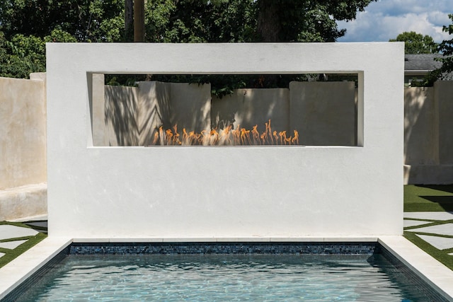 view of swimming pool with an outdoor fireplace