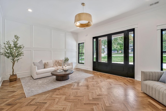 foyer featuring french doors, light parquet flooring, and crown molding