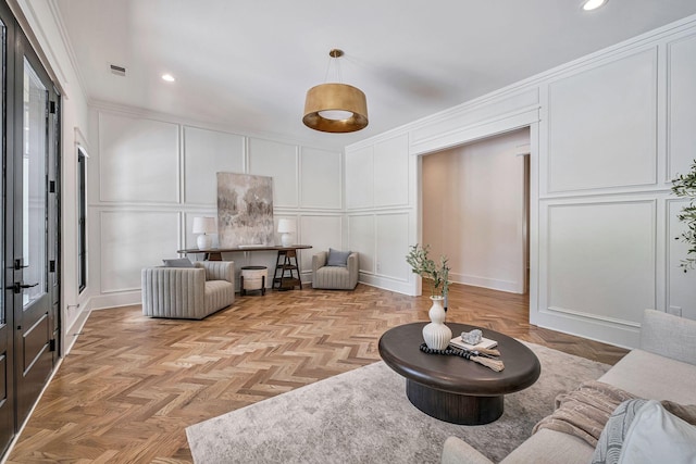 living room with ornamental molding and light parquet flooring