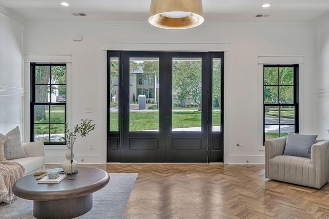 foyer entrance with ornamental molding and light parquet floors