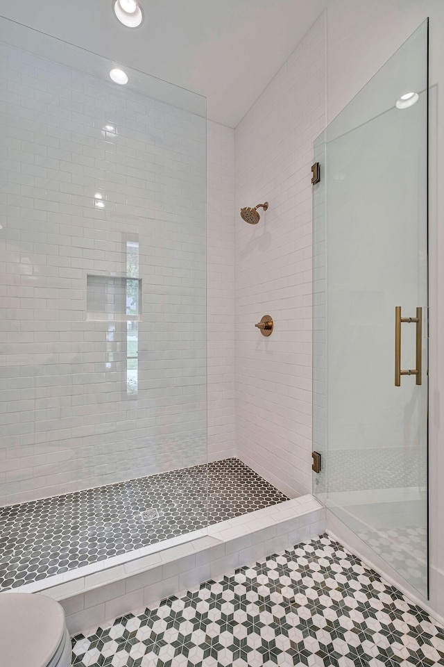 bathroom with toilet and a shower with shower door