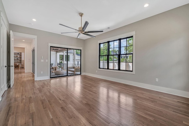 unfurnished room with hardwood / wood-style flooring, ceiling fan, and a wealth of natural light