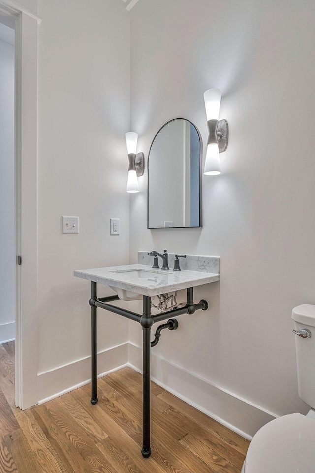 bathroom with wood-type flooring, sink, and toilet