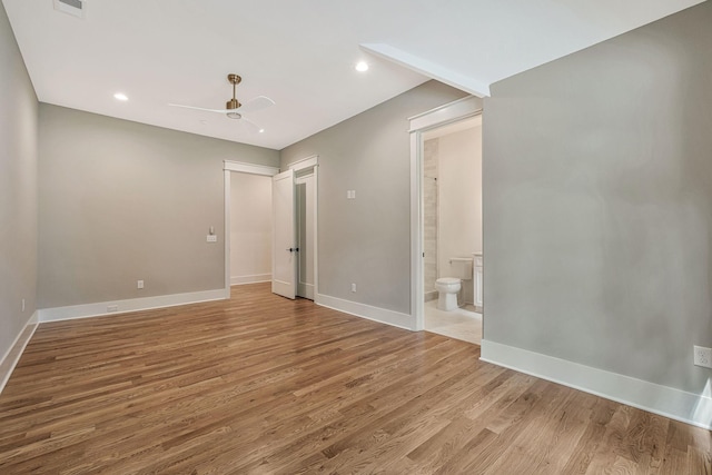 interior space with ceiling fan, ensuite bath, and light hardwood / wood-style flooring