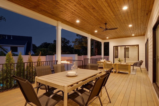 deck at night with ceiling fan and an outdoor hangout area