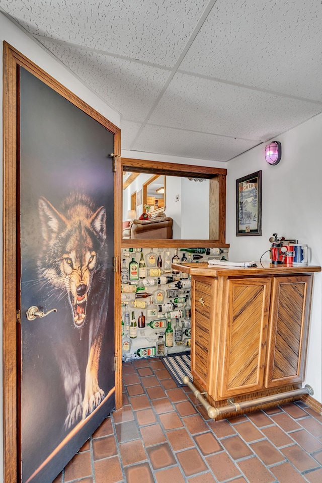 bar with tile countertops and a paneled ceiling