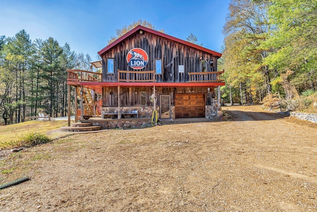 rear view of property featuring covered porch and a garage