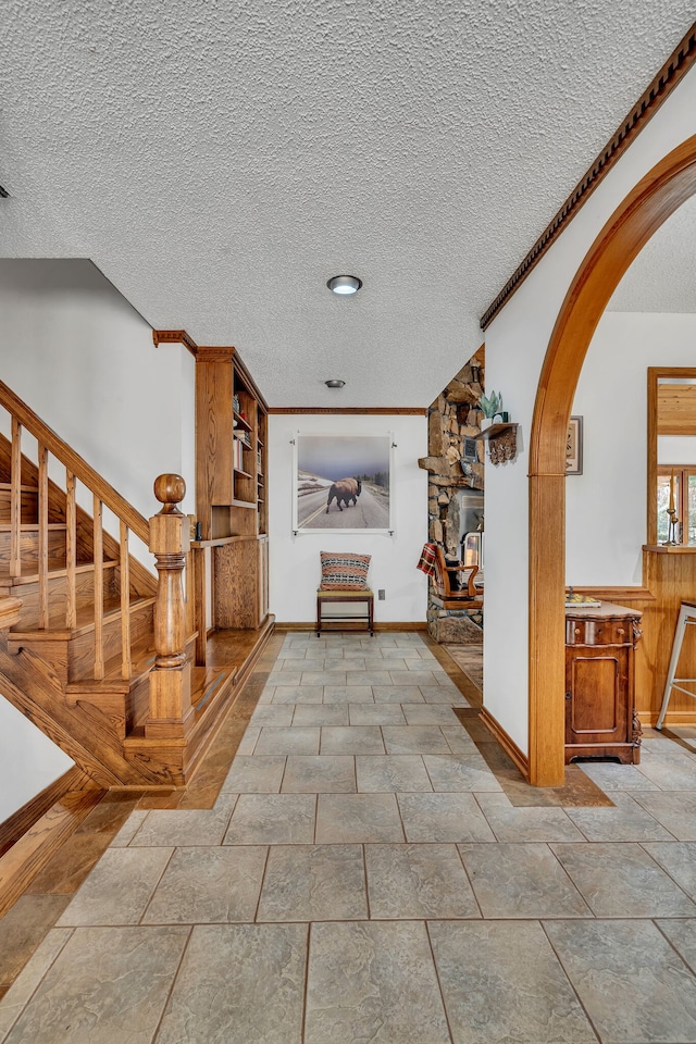 entryway with a textured ceiling and tile patterned flooring