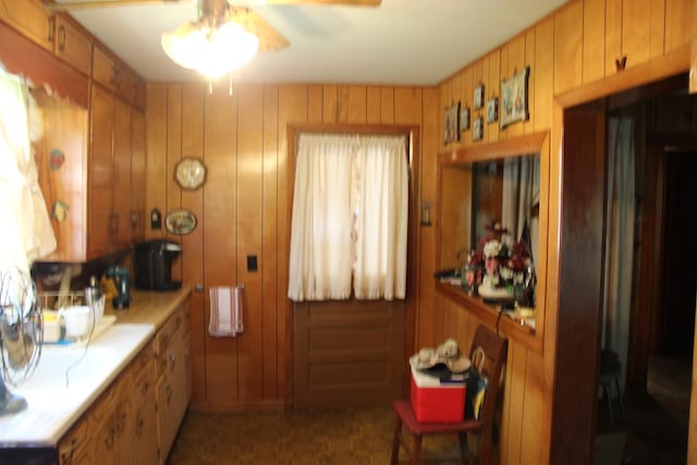 kitchen featuring wood walls and ceiling fan