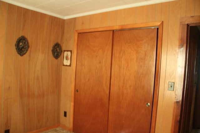 unfurnished bedroom featuring a closet and wood walls