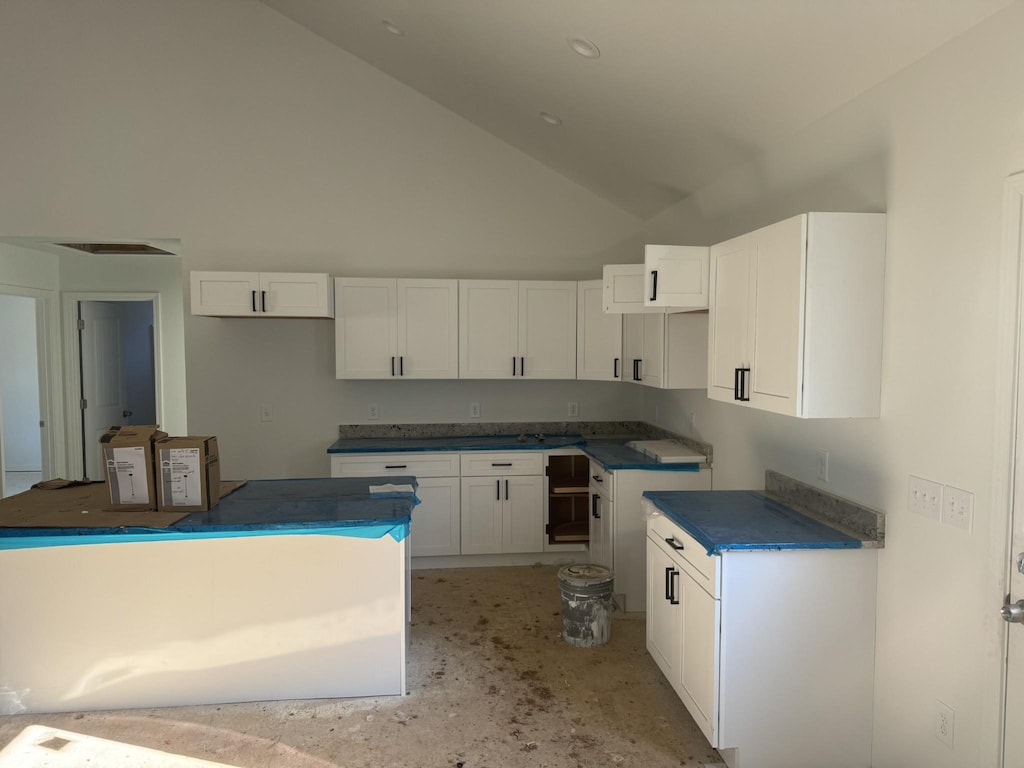 kitchen with white cabinetry and lofted ceiling