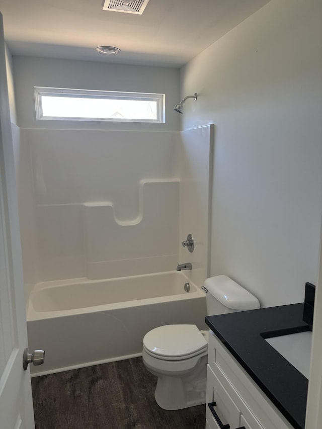 bathroom featuring vanity, shower / tub combination, visible vents, toilet, and wood finished floors