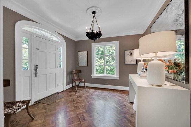 entryway with crown molding, dark parquet flooring, and a notable chandelier