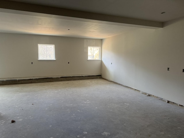 unfurnished room with beam ceiling