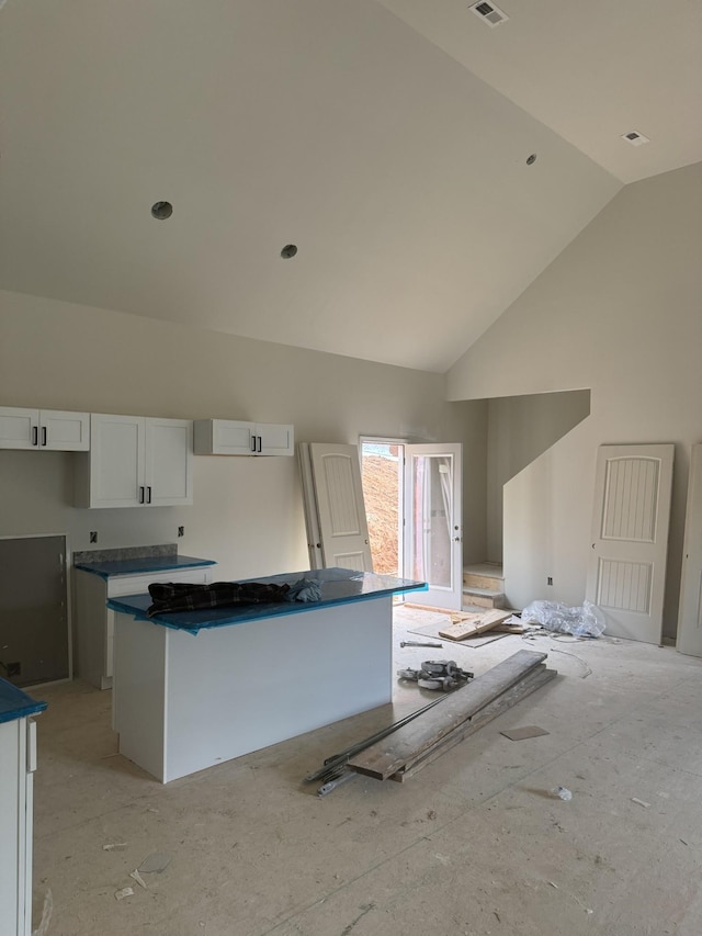 kitchen with white cabinetry and high vaulted ceiling