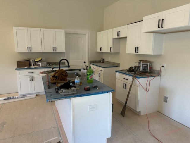 kitchen with sink, white cabinetry, and a kitchen island with sink