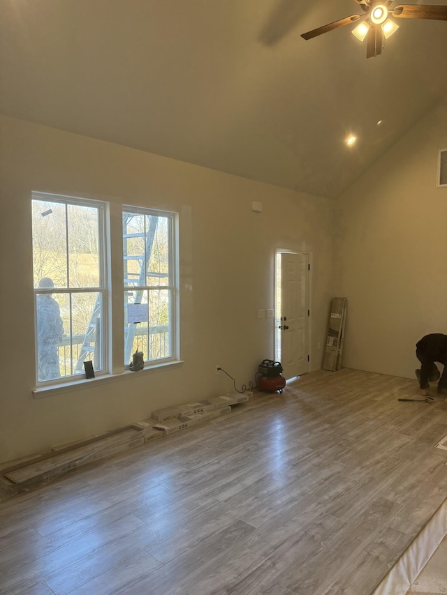 spare room with light hardwood / wood-style flooring, vaulted ceiling, and ceiling fan