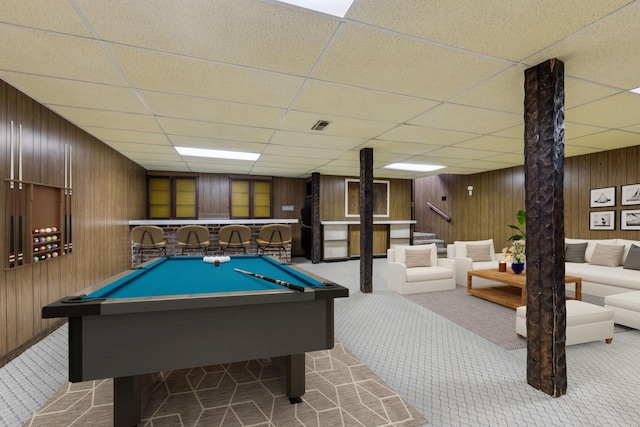 recreation room featuring a drop ceiling, pool table, light carpet, and wooden walls