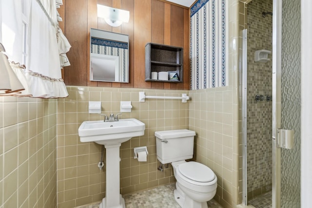 bathroom with walk in shower, toilet, and tile walls