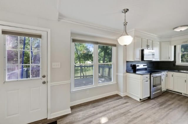 kitchen with decorative light fixtures, stainless steel appliances, and white cabinets