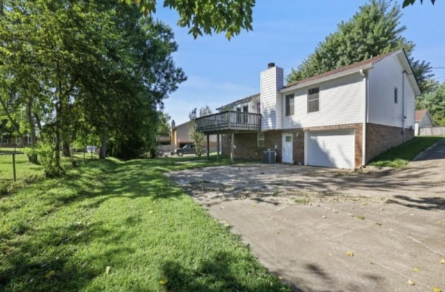 view of property exterior featuring a garage, a lawn, and a wooden deck