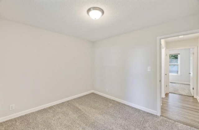 spare room featuring carpet floors and a textured ceiling