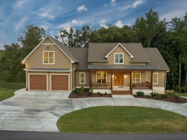 view of front of house featuring a front lawn, a garage, and covered porch