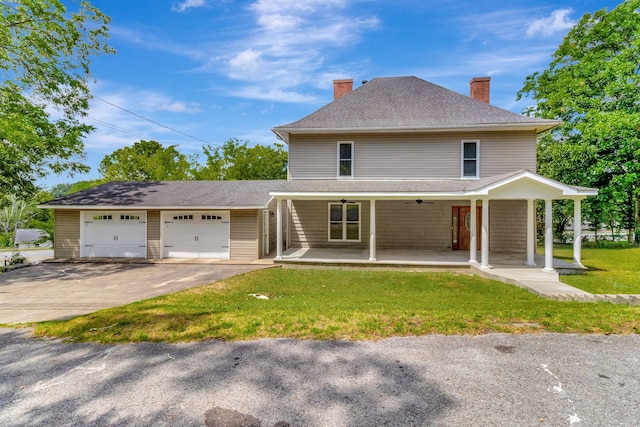 view of front of property featuring a garage, a front lawn, and covered porch