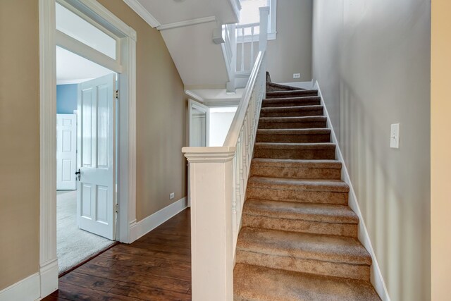 staircase with dark hardwood / wood-style floors and ornamental molding