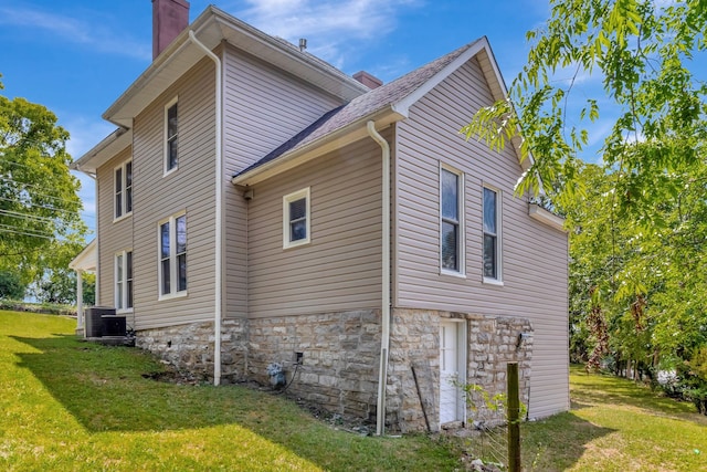 view of home's exterior featuring cooling unit and a yard