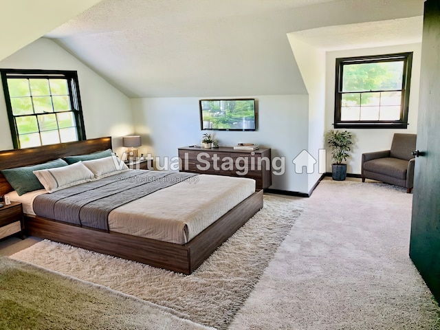 carpeted bedroom with a textured ceiling and vaulted ceiling