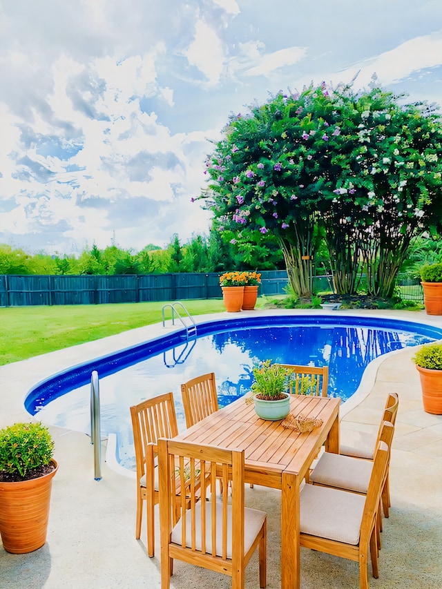 view of pool with a patio area and a yard