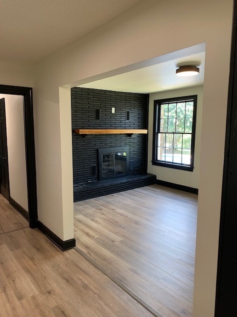 unfurnished living room featuring a fireplace and light wood-type flooring