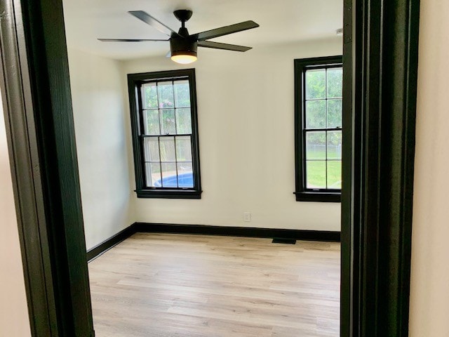 empty room featuring light wood-type flooring and ceiling fan