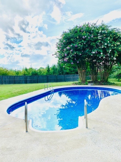 view of pool with a lawn