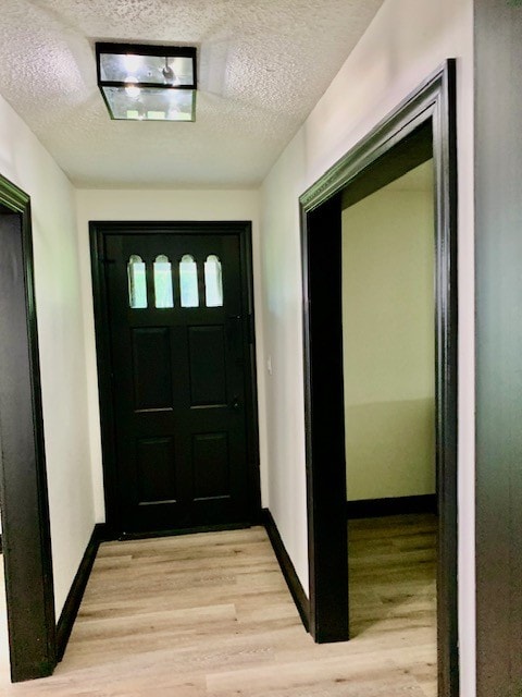 entryway with a textured ceiling and light hardwood / wood-style floors