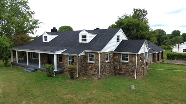 back of house with a porch and a yard