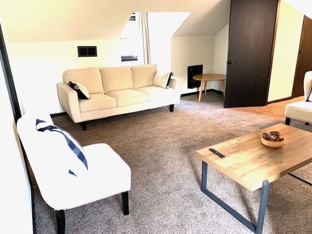 living room featuring carpet floors and lofted ceiling