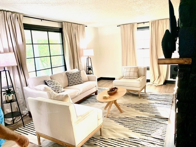 living room featuring light hardwood / wood-style flooring and a textured ceiling