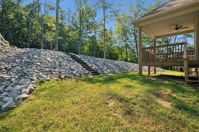 view of yard featuring ceiling fan and a deck