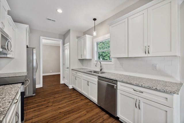 kitchen with dark hardwood / wood-style floors, appliances with stainless steel finishes, white cabinets, backsplash, and sink