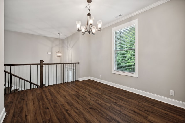 spare room with hardwood / wood-style floors, crown molding, and a chandelier